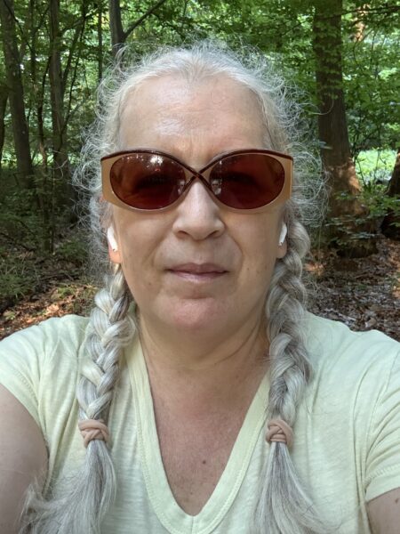 A woman wearing sunglasses with her hair in braids.